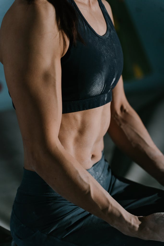 Close-up of a muscular woman resting during an intense workout session indoors.